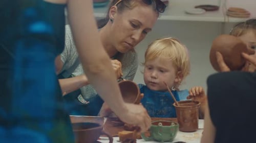 Mother with Kids Learn Pottery and Shape the Clay in the Pottery Studio During Pottery Masterclass
