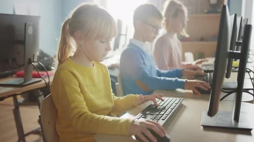 Elementary School Computer Science Classroom: Cute Little Girl Uses Personal Computer, Learning Pro