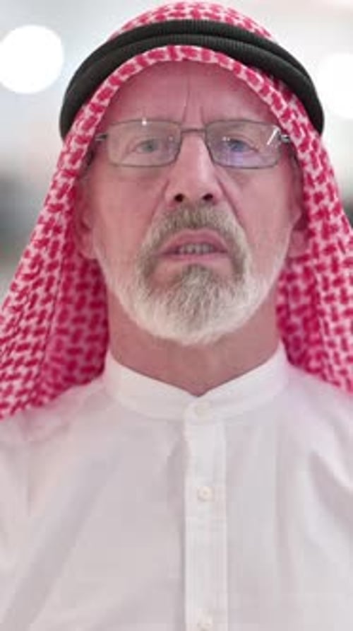 Adult Man in Traditional Headscarf Gesturing and Talking