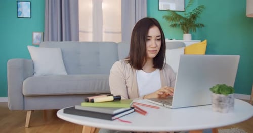 Woman Using Laptop for Online Work at Home