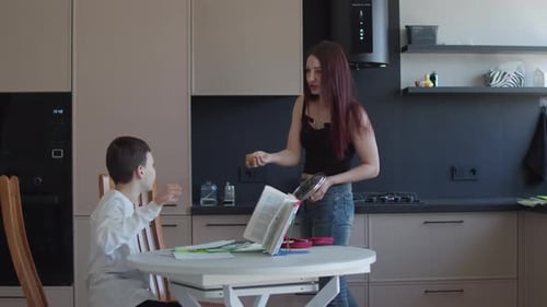 Woman and Boy Study Together in Modern Kitchen