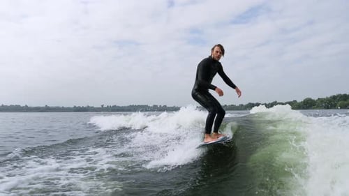 Surfer Skillfully Rides a Wave Showcasing Balance and Agility on the Water Surface