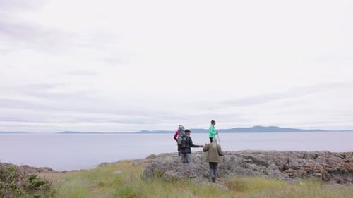 Senior Friends with Hing Poles Hing on Rocks Above Scenic Ocean 5559 Years
