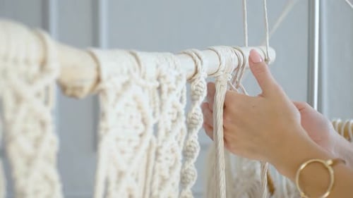 close-up female hands of a master throws a rope on macram