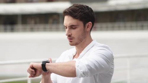 Handsome Man Checking His Smartwatch Outdoors