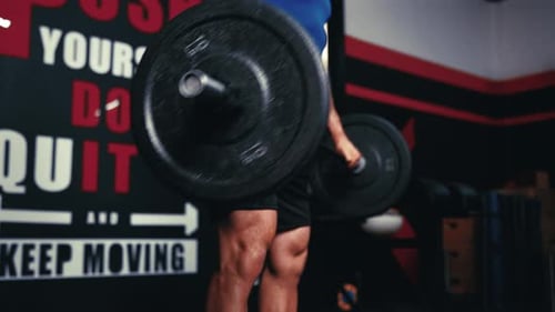 Athletic Man Lifting Barbell Over Head in Gym