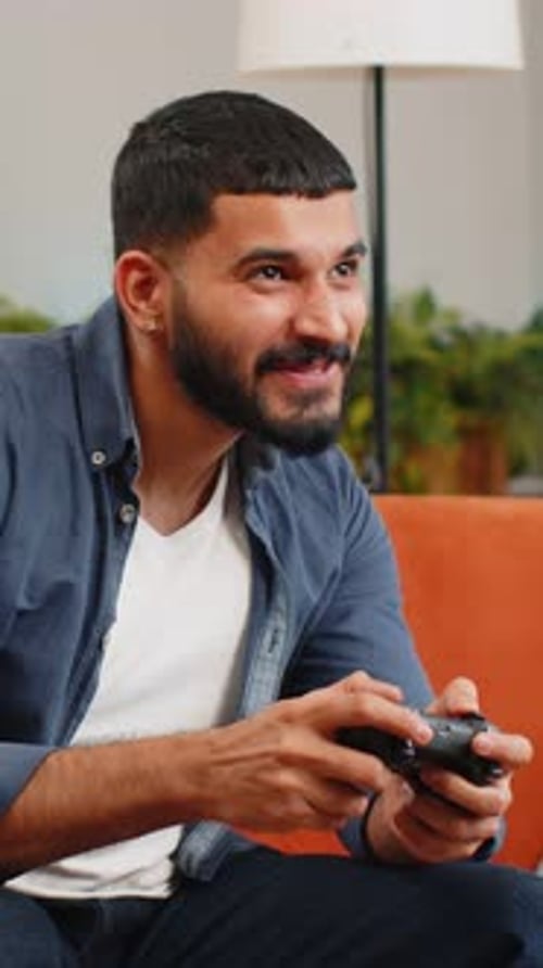 Man Sitting on Couch Playing Video Game