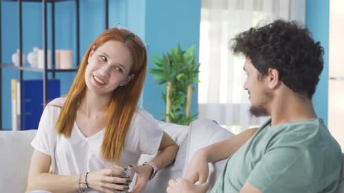 Couple Relaxing and Chatting on Couch at Home
