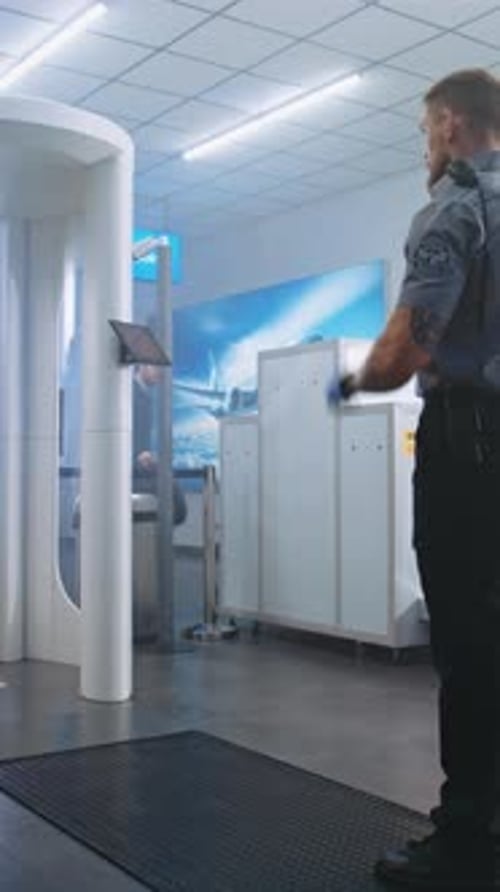 Airport Security Checkpoint Security Officer Checks Passengers for Flight