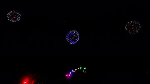 Bright Fireworks are Ignited Lighting Up the Dark Night Sky with Colorful Bursts and Explosions