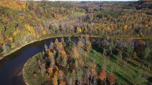 Autumn landscape with river bend and colorful foliage in rural area