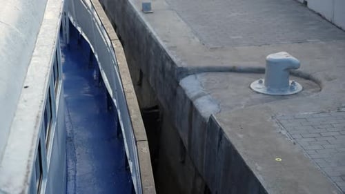 Blaues Schiff legt langsam am betonierten Pier Clip an