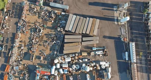 Depósito de salvamento urbano lleno de varios materiales desechados y remolques a la luz del día