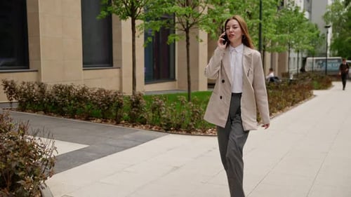 Young Woman Talking on Phone Walking in City