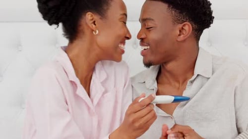 Joyful Couple Celebrating Pregnancy Test Results at Home