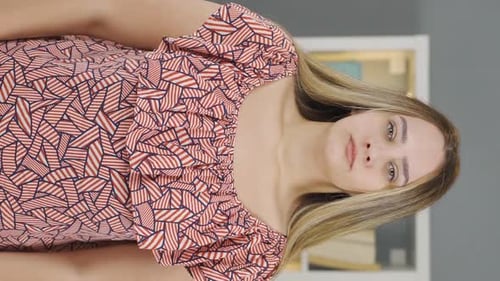 Smiling Woman in Patterned Dress Poses Indoors