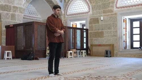 Young Adult Performs Religious Ritual in Ancient Building