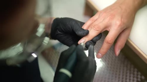 Manicurist Using Tool on Client's Nails