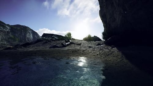 Sandy Beach in Bay Surrounded By Steep Mountains in Sunset