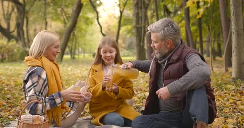 Loving Family Having Picnic in an Autumn Park