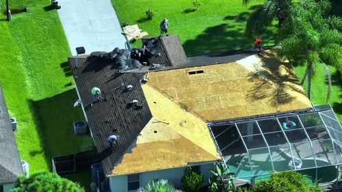 Workers Changing Old Asphalt Shingles to New on Private House Rooftop Roof Repair on Florida Home