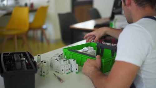 Electrician Assembles Electrical Panel Fuse Box in Workshop Worker Installs Energy Meter Switches