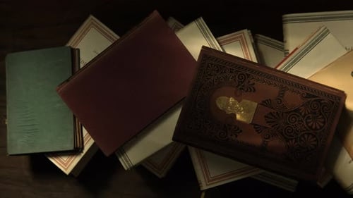 Top View of a Stack of Antique Books Lying on a Wooden Table
