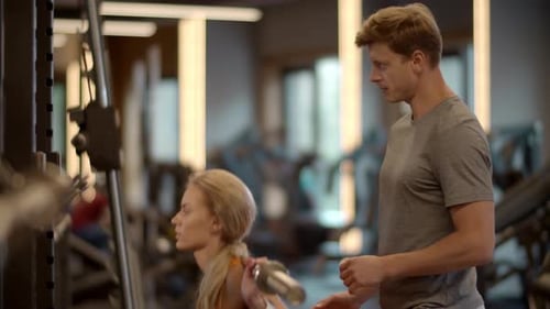 Closeup Beautiful Female Athlete Making Barbell Squats In Fitness Center. Attractive Fitness Coup...