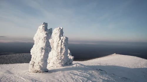 Aerial View of Breathtaking Snow Covered Stone Formations on a Blue Cloudy Sky Background Clip