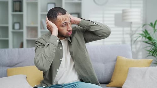 Tired man suffers because of noisy neighbors. Poor soundproofing in the apartment building and thin