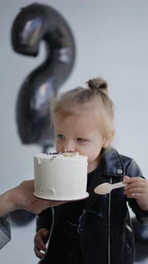 Cute Girl Eating Cake at Birthday Party