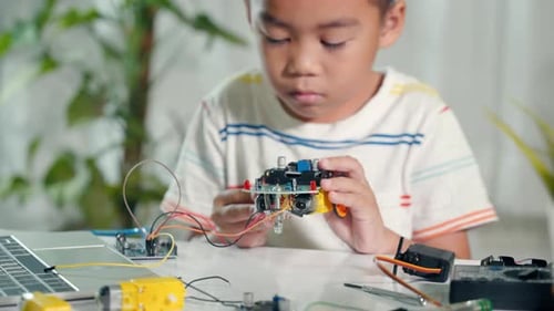 Boy Building a Robot Car at Home