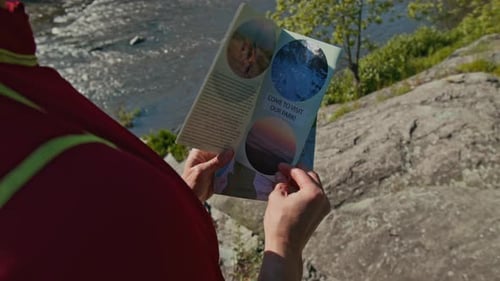 Tourist Reading National Park Brochure during Summer Trip