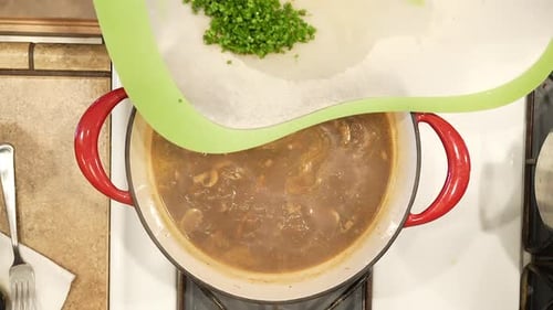 Adding Herbs to Stew in Home Kitchen