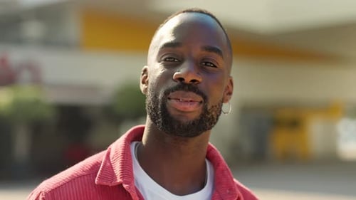 Smiling Young African Man Standing on City Street Looking at Camera Portrait