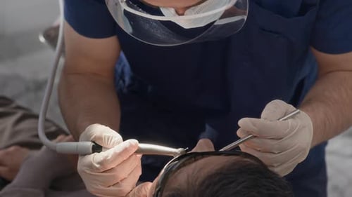 Dentist Performing Dental Procedure on Patient in Clinic