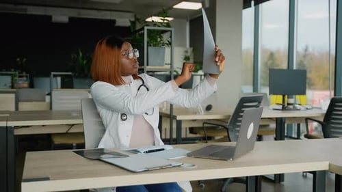 Female Doctor Examining X-ray in Modern Office