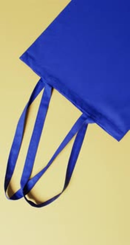 Vídeo vertical de bolsa de lona azul con espacio para copiar sobre fondo amarillo