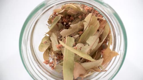 Dried linden flowers in a jar close up 4K