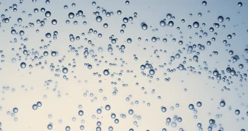 Many water bubbles in blue water close up, abstract water wave with bubbles in slow motion.
