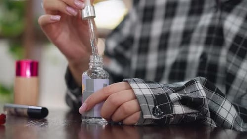 Closeup View of Lady Opening Face Serum Bottle