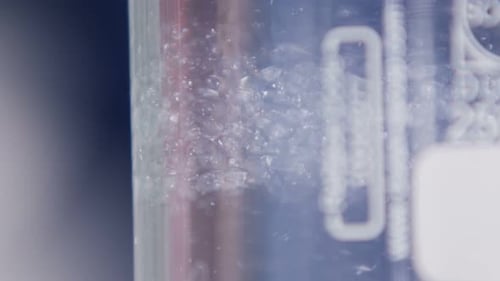 White Parts Turn Round in Clear Substance Macro