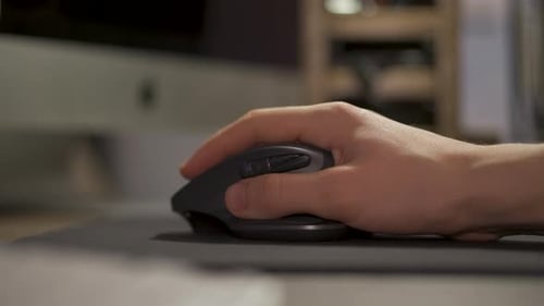 Mano moviendo el ratón del ordenador sobre la alfombrilla del ratón - primer plano