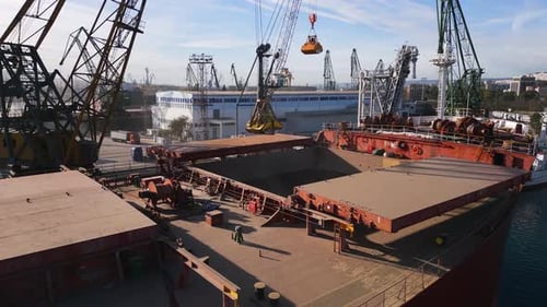 Aerial View of Big Cargo Ship Bulk Carrier is Loaded with Grain of Wheat in Port at Sunset