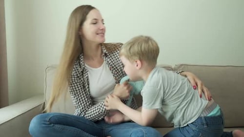 Mother and Child Play Together with Toy on Couch