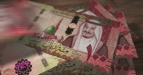 Saudi Arabia Rial 100 money banknotes falling on the table