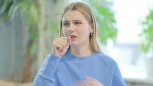 Woman Coughing in an Indoor Setting