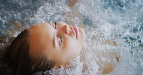 Close up of an young female is enjoying and having relax in a bath tube in a luxury wellness cente