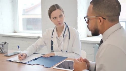 Female Doctor Consulting with Male Patient in Clinic