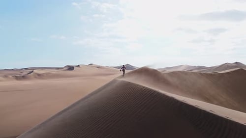 Two Hikers Meet Atop the Sand Dunes of Peru